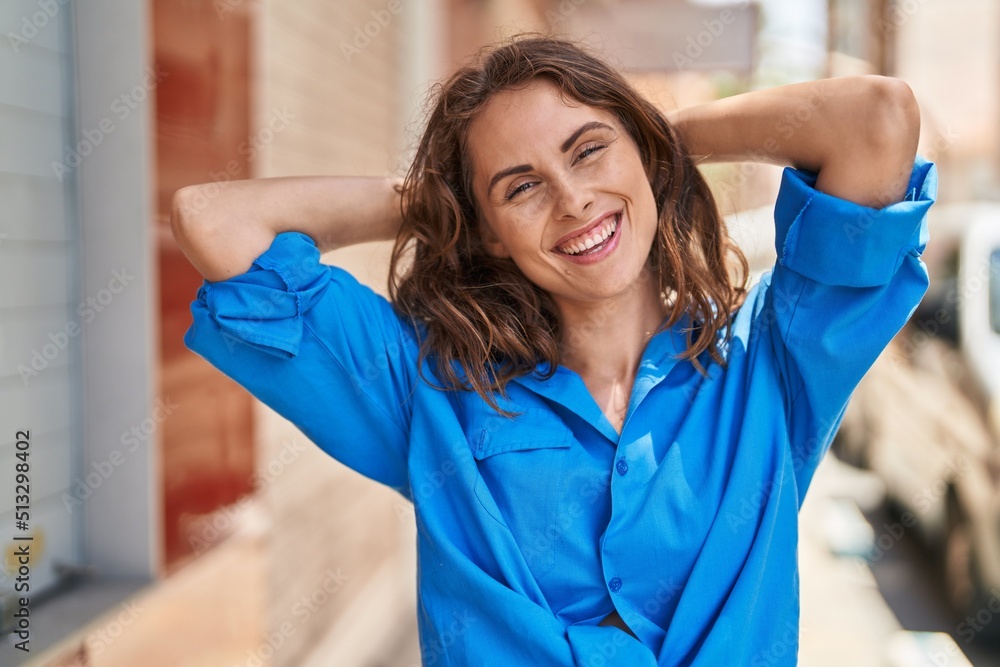 Young woman smiling confident relaxed with hands on head at street Young woman smiling confident relaxed with hands on head at street
