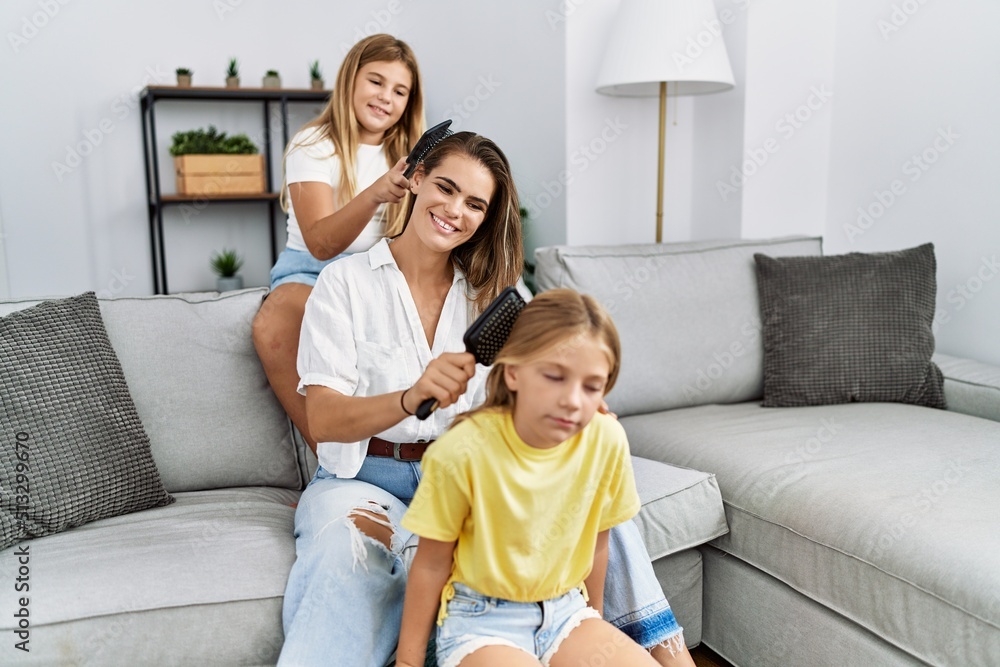 Mother and daughters smiling confident combing hair at home Mother and daughters smiling confident combing hair at home