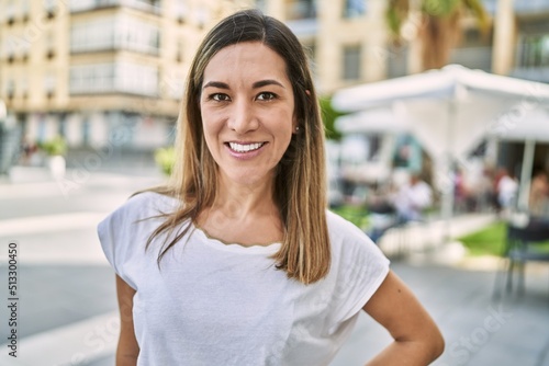 Young hispanic woman smiling confident at street Free Download Young hispanic woman smiling confident at street - GFXLoad