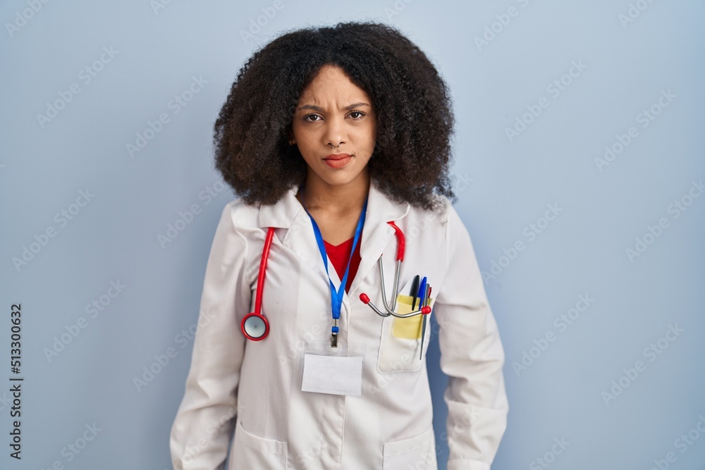 Young african american woman wearing doctor uniform and stethoscope skeptic and nervous, frowning upset because of problem. negative person. Young african american woman wearing doctor uniform and stethoscope skeptic and nervous, frowning upset because of problem. negative person.