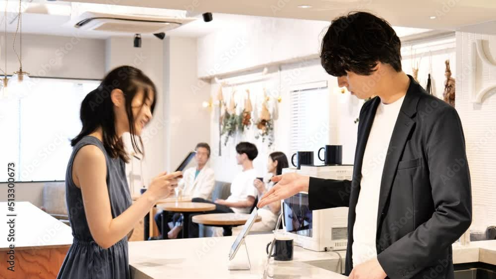 レストランでバーコード決済をする女性