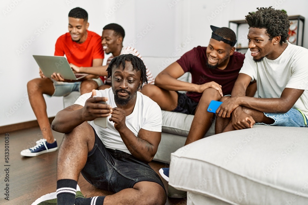Group of african american people smiling happy using smartphone and laptop at home. Group of african american people smiling happy using smartphone and laptop at home.