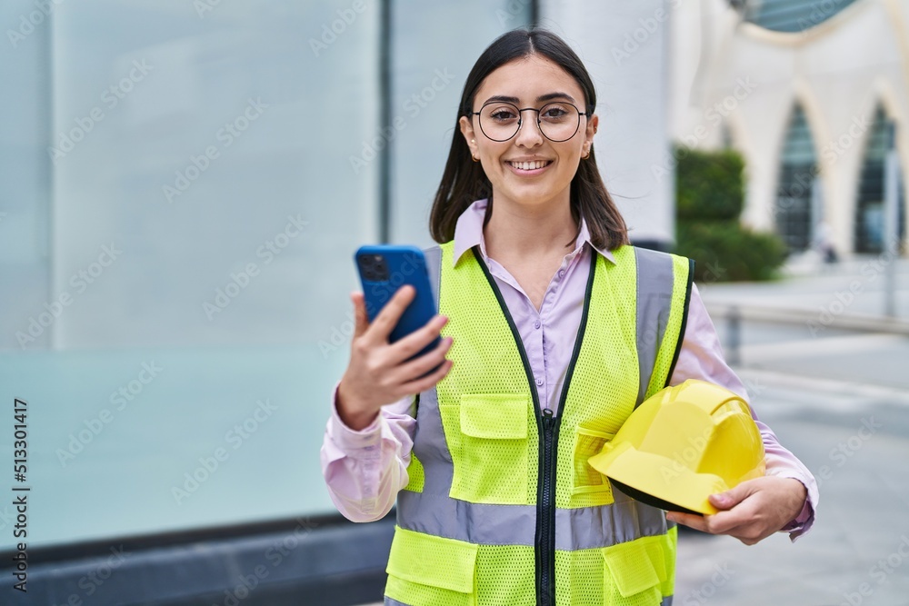 Young hispanic woman architect using smartphone at street Young hispanic woman architect using smartphone at street