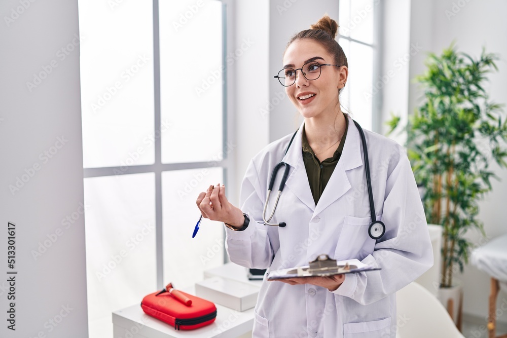 Young woman wearing doctor uniform speaking at clinic Young woman wearing doctor uniform speaking at clinic