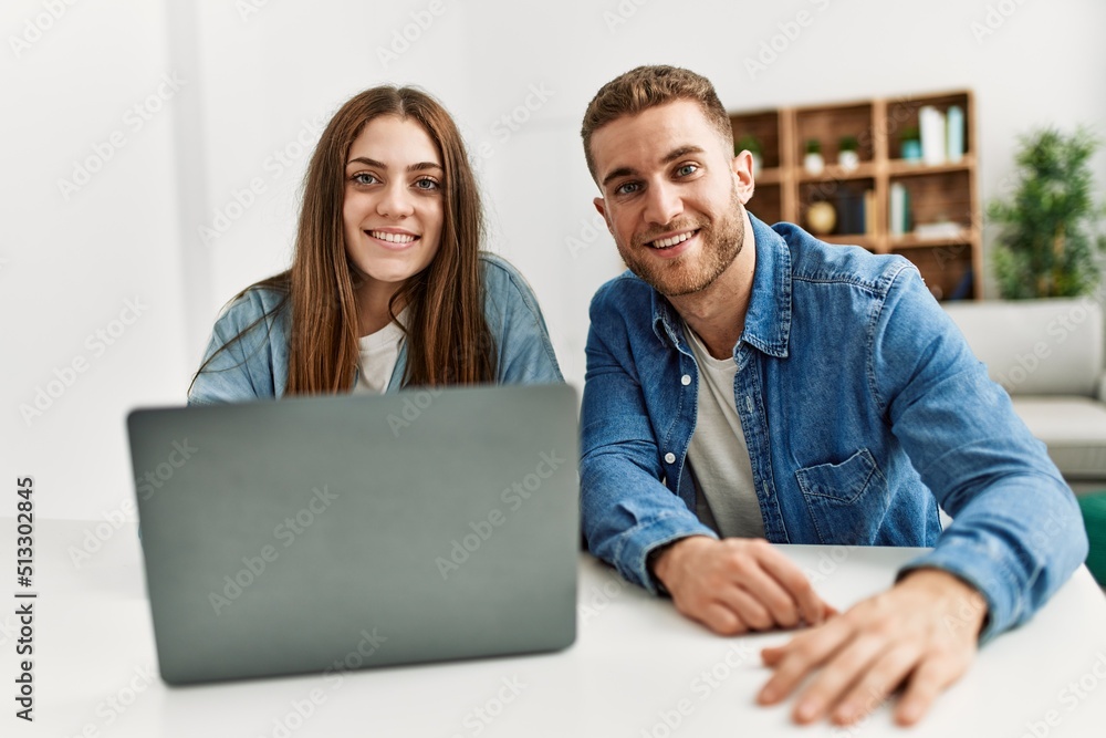 Young caucasian couple smiling happy using laptop at home. Young caucasian couple smiling happy using laptop at home.