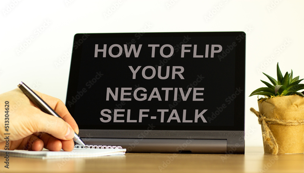 Flip negative self-talk symbol. Concept words How to flip your negative self-talk on the black tablet. Businessman hand with pen. Psychological flip negative self-talk concept. Copy space. Flip negative self-talk symbol. Concept words How to flip your negative self-talk on the black tablet. Businessman hand with pen. Psychological flip negative self-talk concept. Copy space.