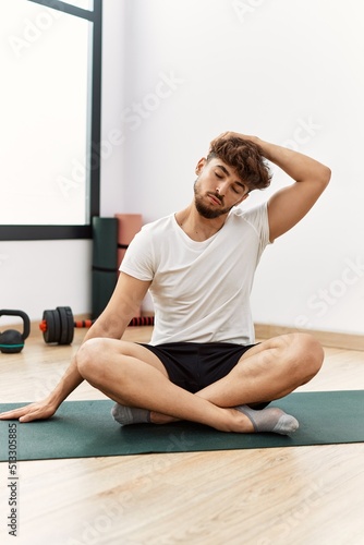 Young arab man stretching at sport center