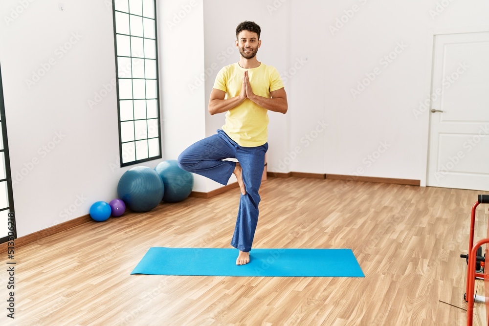 Young arab sporty man smiling happy training yoga at sport center.