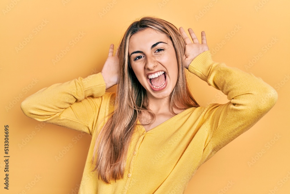Beautiful hispanic woman wearing casual yellow sweater smiling cheerful playing peek a boo with hands showing face. surprised and exited Beautiful hispanic woman wearing casual yellow sweater smiling cheerful playing peek a boo with hands showing face. surprised and exited