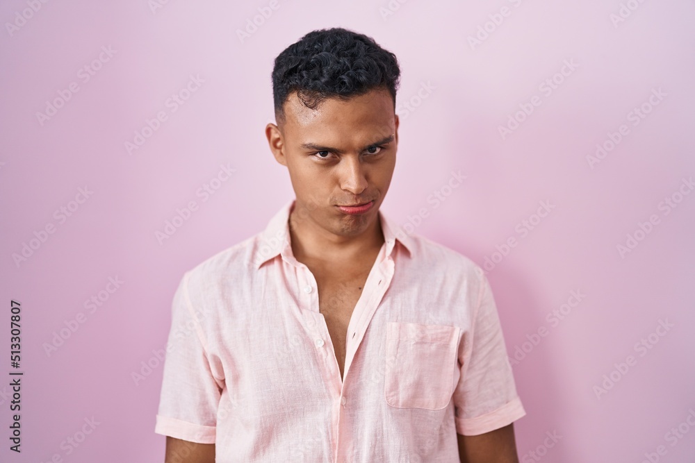 Young hispanic man standing over pink background depressed and worry for distress, crying angry and afraid. sad expression. Young hispanic man standing over pink background depressed and worry for distress, crying angry and afraid. sad expression.