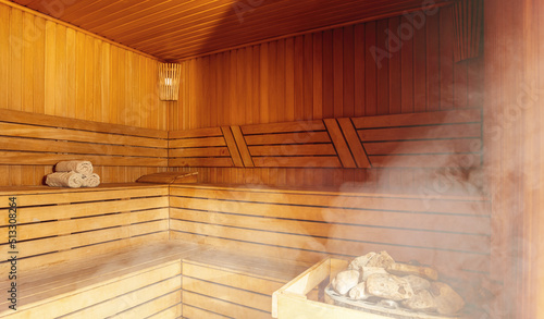 Interior of Finnish sauna  classic wooden sauna with hot steam. Russian bathroom. Relax in hot sauna with steam. Wooden interior baths  wooden benches and loungers accessories for sauna  spa complex
