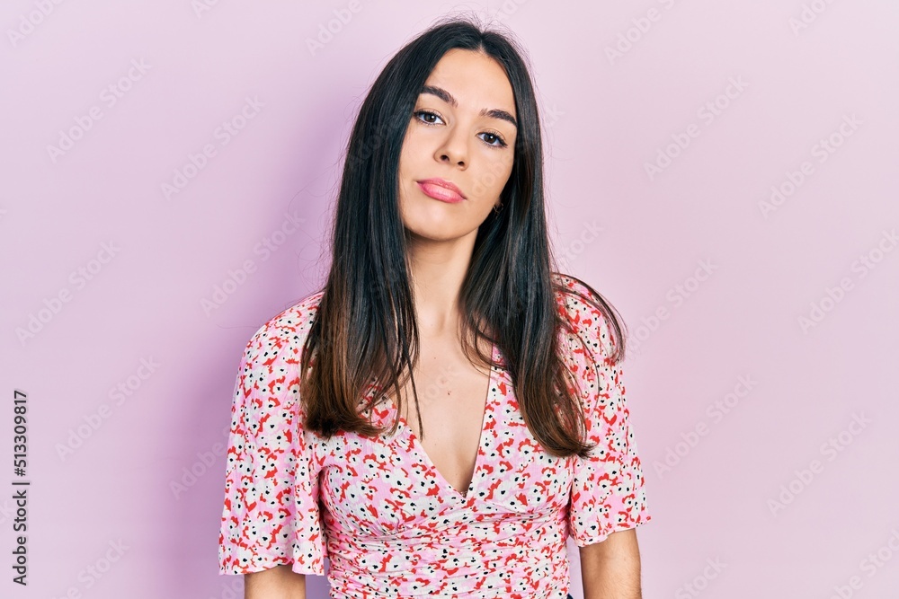 Young brunette woman wearing summer dress relaxed with serious expression on face. simple and natural looking at the camera. Young brunette woman wearing summer dress relaxed with serious expression on face. simple and natural looking at the camera.