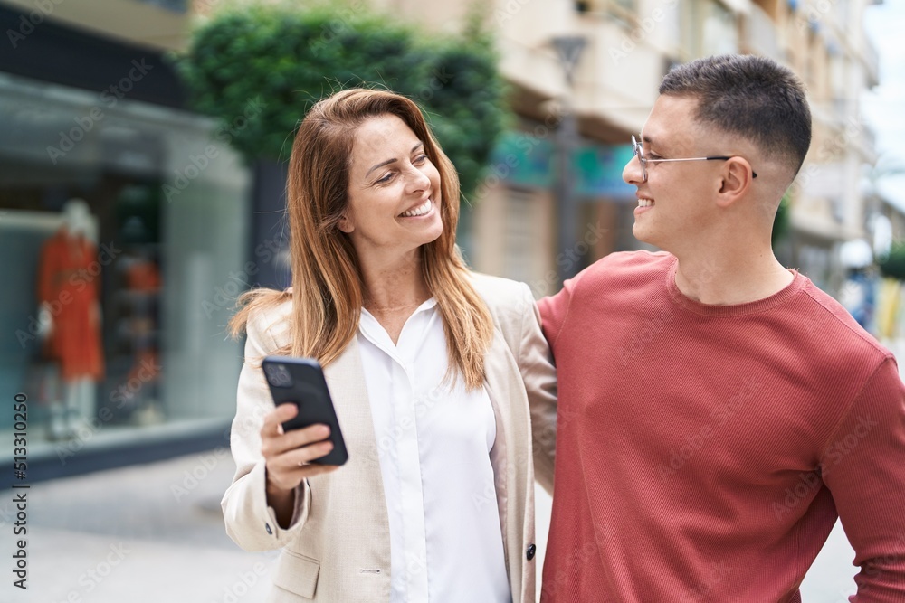 Man and woman mother and son smiling confident using smartphone at street Man and woman mother and son smiling confident using smartphone at street