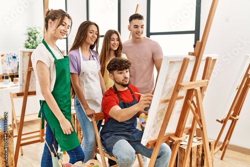 Group of people smiling happy and looking draw of partner at art studio.