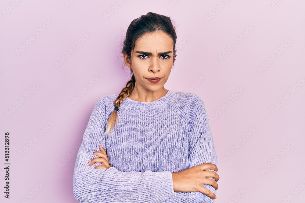 Young hispanic girl wearing casual clothes skeptic and nervous, disapproving expression on face with crossed arms. negative person. Young hispanic girl wearing casual clothes skeptic and nervous, disapproving expression on face with crossed arms. negative person.