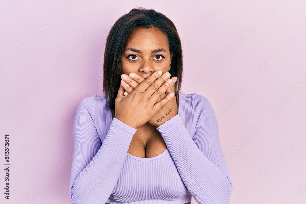 Young african american girl wearing casual clothes shocked covering mouth with hands for mistake. secret concept. Young african american girl wearing casual clothes shocked covering mouth with hands for mistake. secret concept.
