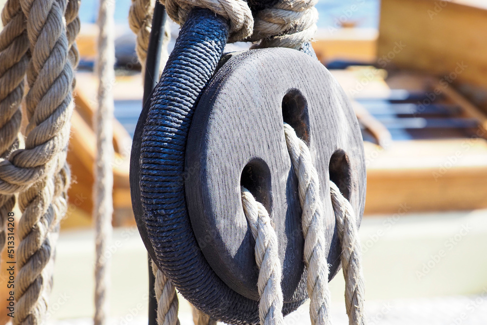 Part of an old sailing wooden ship with pulleys, knotted ropes and