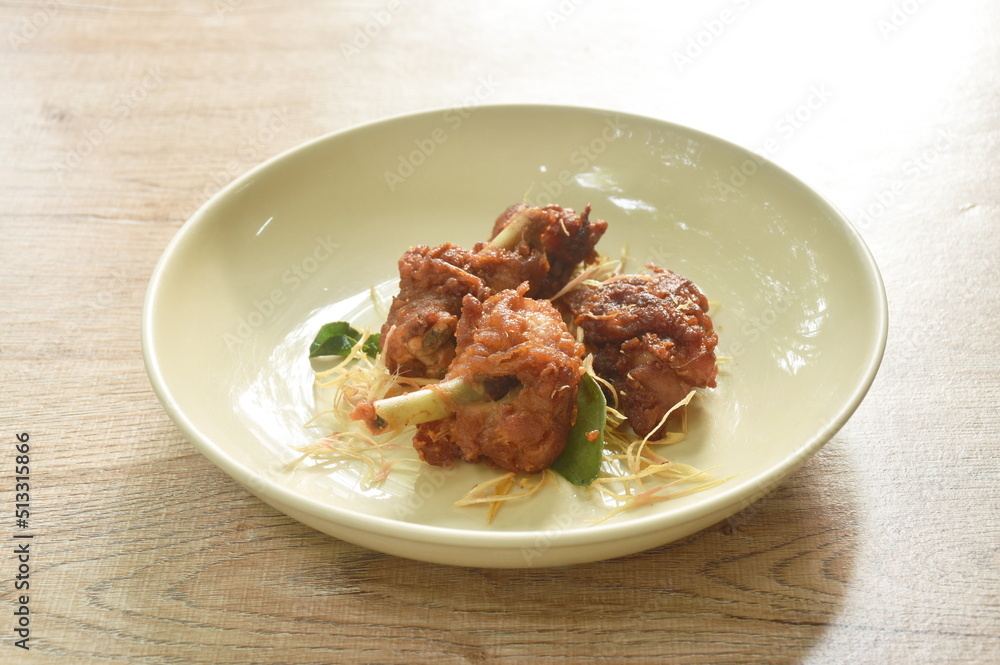 spicy fried chicken with chili and slice lemon grass on dish spicy fried chicken with chili and slice lemon grass on dish