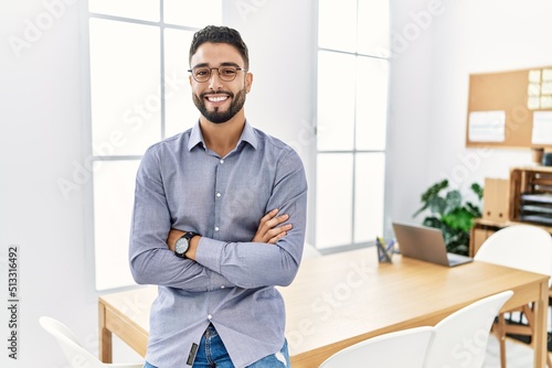 Young arab man smiling confident standing with arms crossed gesture at office photo