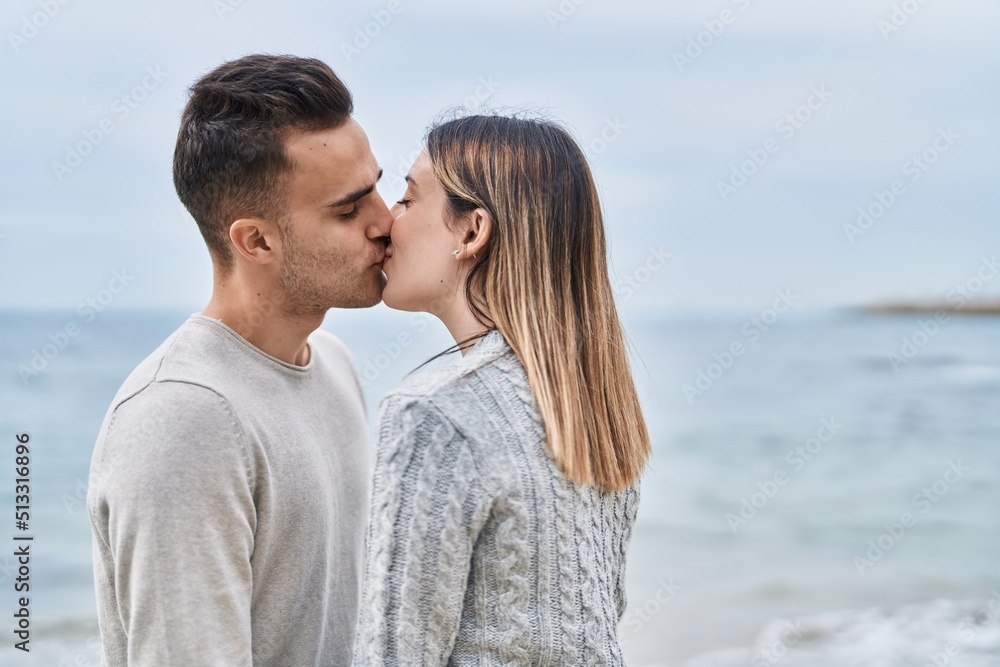 Man and woman couple hugging each other kissing at seaside Man and woman couple hugging each other kissing at seaside