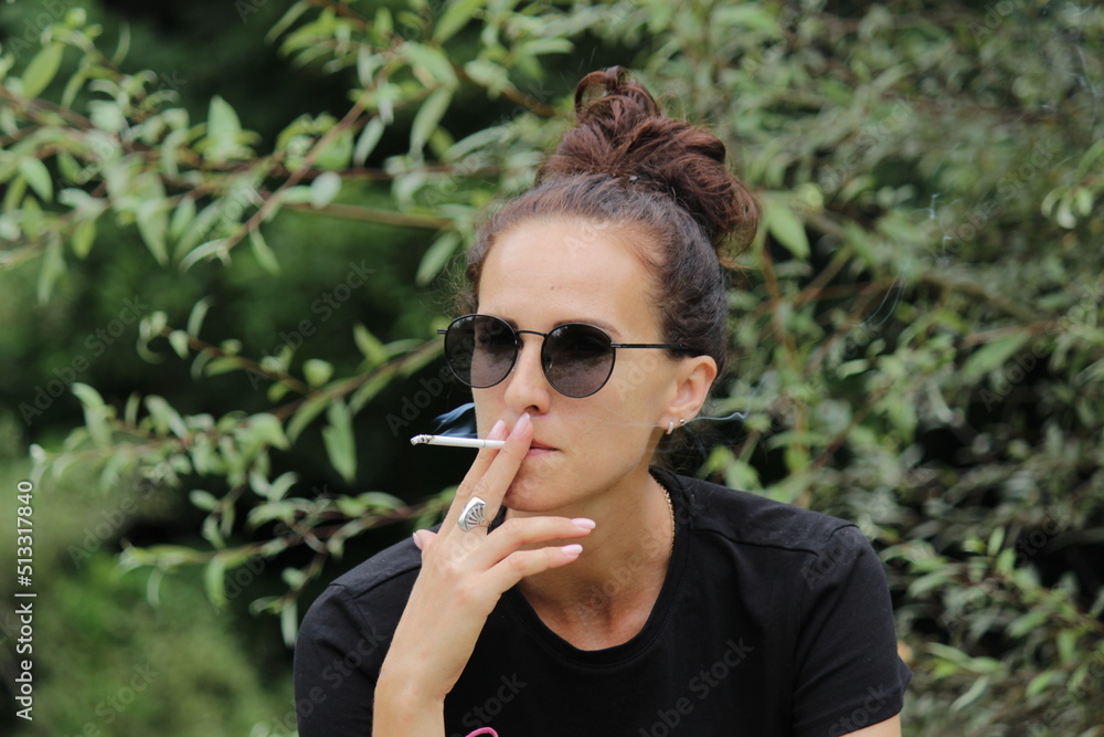 the girl is sitting and smoking a cigarette the girl is sitting and smoking a cigarette