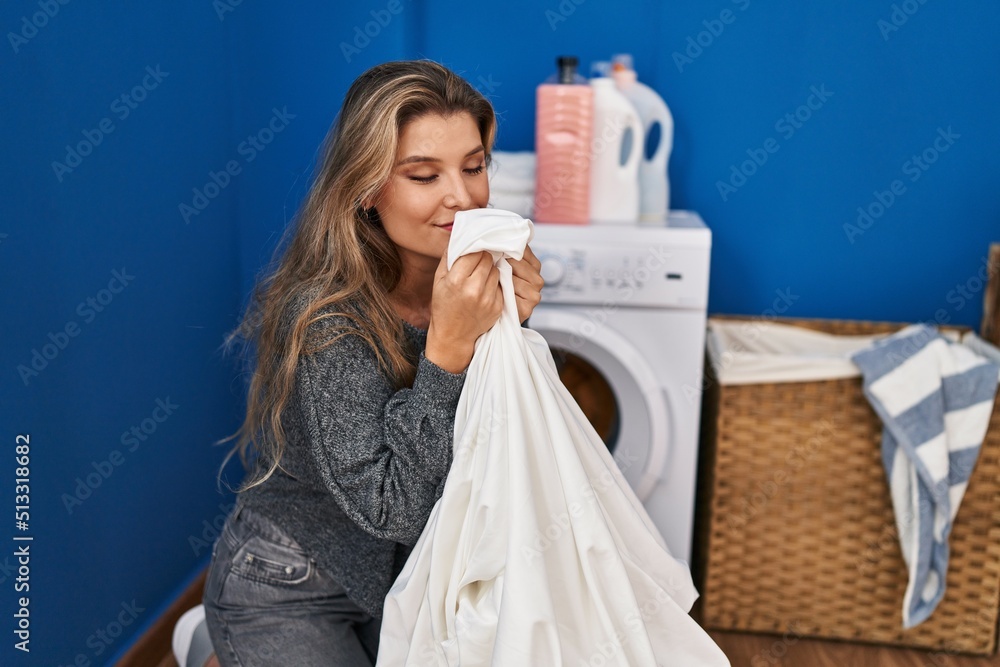 Young blonde woman smiling confident smelling clothes at laundry room Young blonde woman smiling confident smelling clothes at laundry room