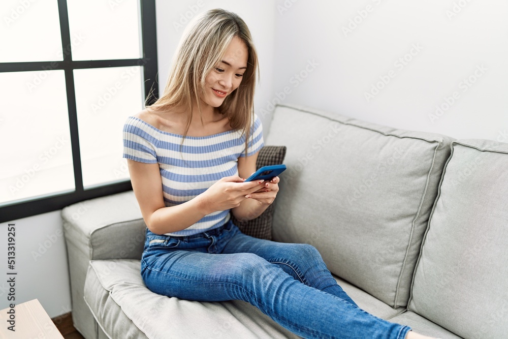 Young chinese woman smiling confident using smartphone at home Young chinese woman smiling confident using smartphone at home