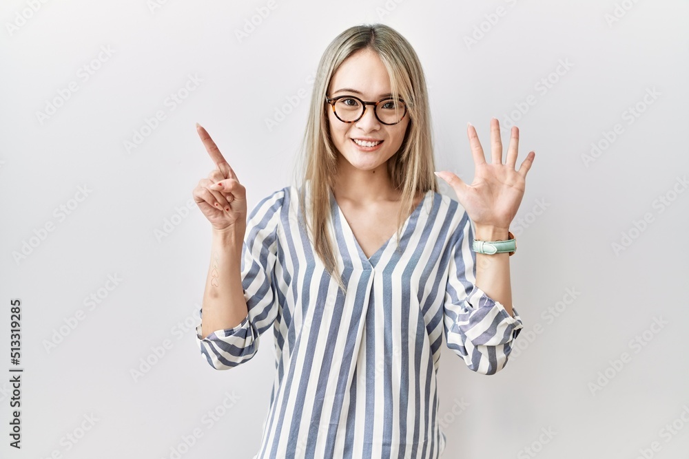 Asian young woman wearing casual clothes and glasses showing and pointing up with fingers number six while smiling confident and happy. Asian young woman wearing casual clothes and glasses showing and pointing up with fingers number six while smiling confident and happy.