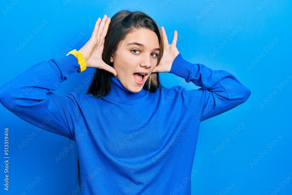 Young brunette girl wearing turtleneck sweater smiling cheerful playing peek a boo with hands showing face. surprised and exited Young brunette girl wearing turtleneck sweater smiling cheerful playing peek a boo with hands showing face. surprised and exited