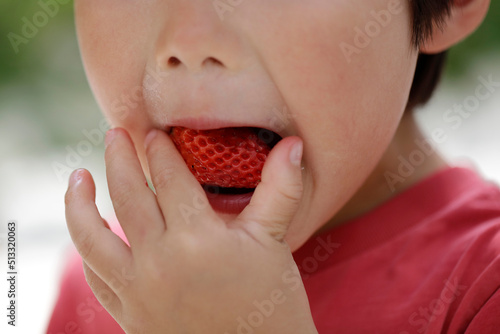 child eating strawberries