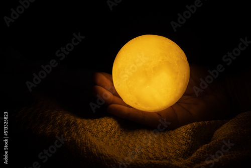 Принти на полотні My hands are holding the moon on black background.