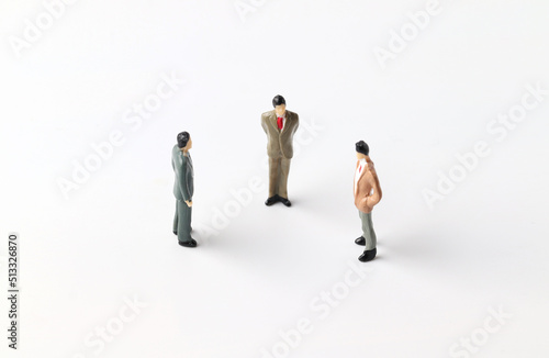 Three miniature people discussing work ideas. Team work concept. © Sai