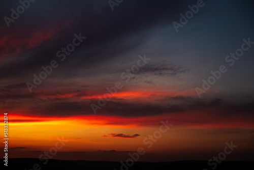 Beautiful landscape of sunset with dark colourful clouds. Natural background. © Lalandrew