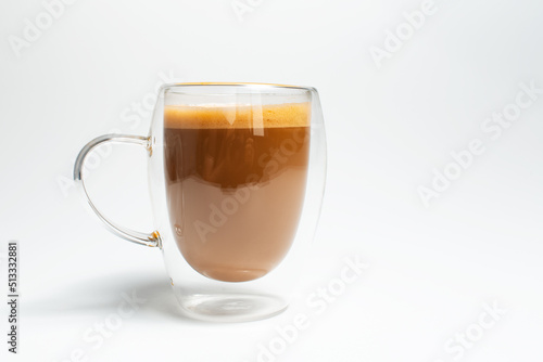 Double walled glass mug with coffee and vegan milk on white, close-up view.