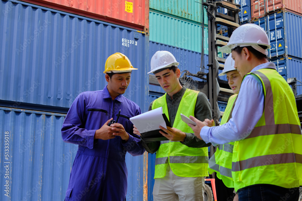 A Group of multiracial workers people in safety uniforms and hard hats work at logistics terminal with many stacks of containers, loading control shipping goods for the cargo transportation industry. A Group of multiracial workers people in safety uniforms and hard hats work at logistics terminal with many stacks of containers, loading control shipping goods for the cargo transportation industry.