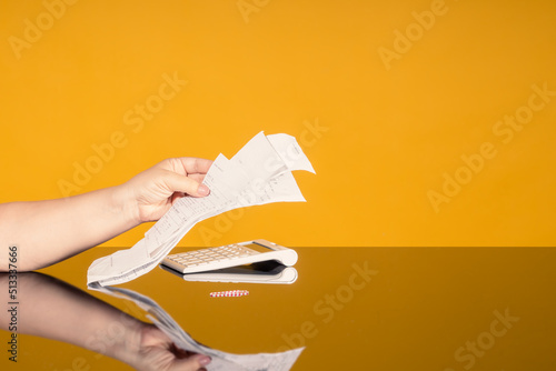 Women's hands with a stack of paid checks. The concept of doing home bookkeeping, keeping track of expenses and income, growing debts, filling out tax returns.