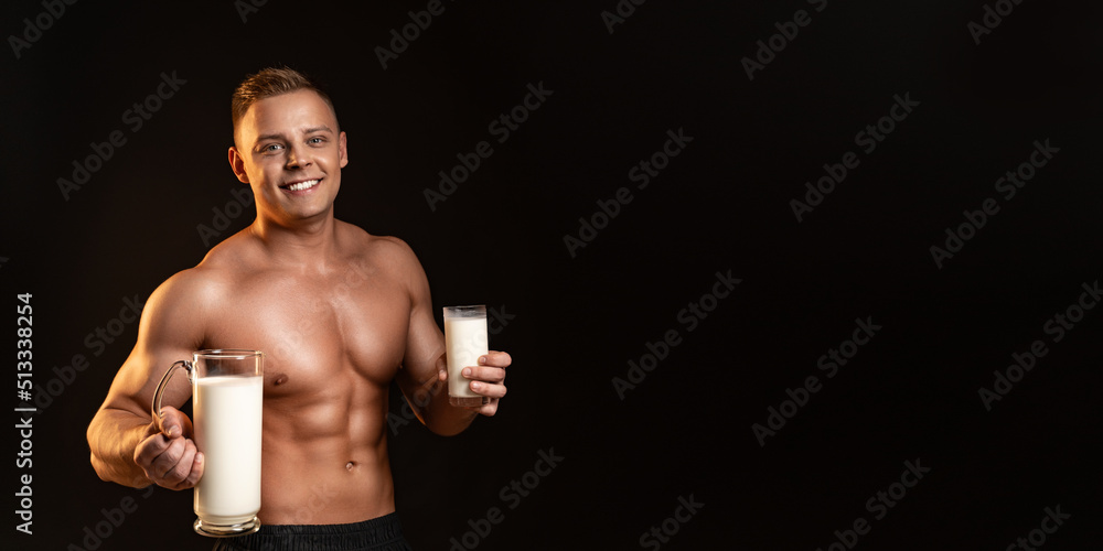 Muscular guy bodybuilder posing on white background. Athletic man holding a bottle of milk in