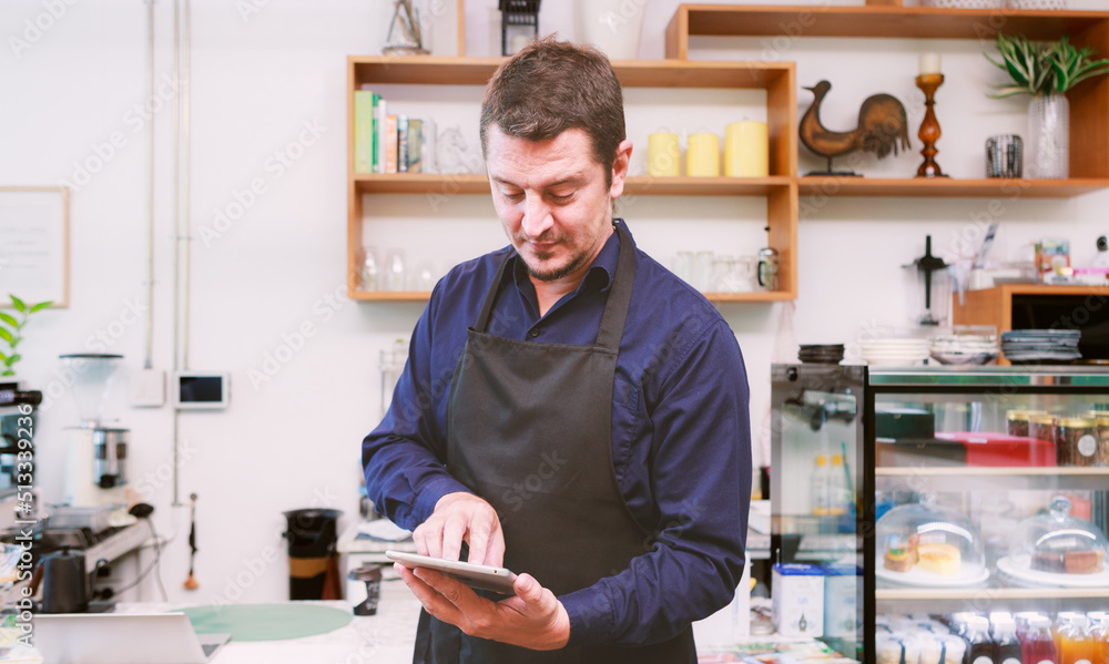 Male barista using tablet At the counter in cafes and restaurants Make your business more accessible with technology. Male barista using tablet At the counter in cafes and restaurants Make your business more accessible with technology.