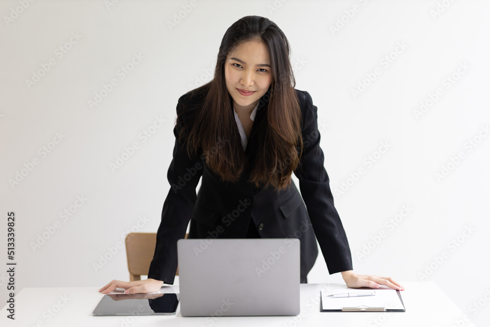 Portrait of a charming Asian businesswoman or manager at her desk in the office. Beautiful secretary in the office. Portrait of a charming Asian businesswoman or manager at her desk in the office. Beautiful secretary in the office.