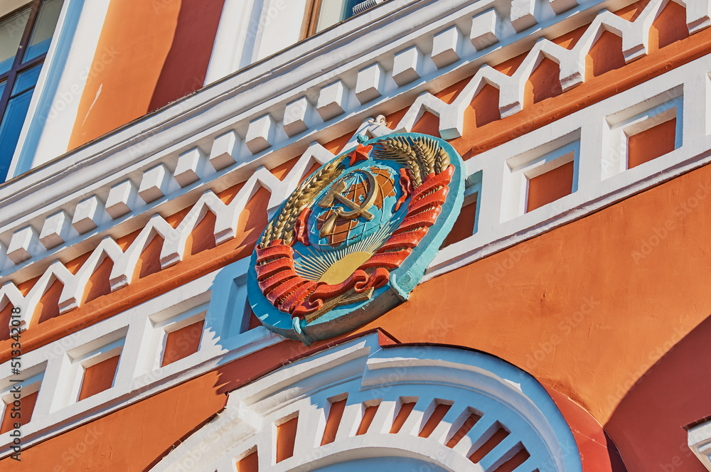Code Languages. Red Ribbin Coat of arms of the USSR on the facade of an old building in red and ...