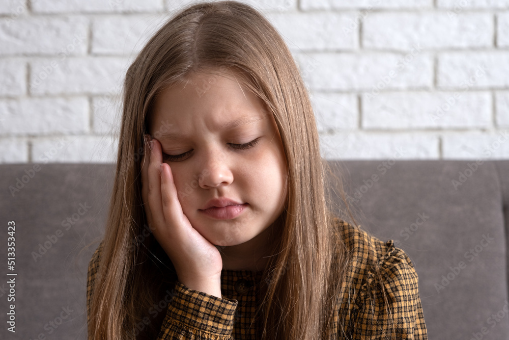 Little girl with toothache. A little girl has a swollen cheek due to a
