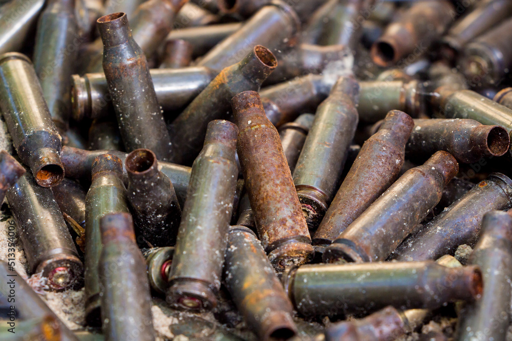 used shells from 5.45 caliber ammunition (from AK-74 5.45×39mm), rust and erosion marks are visible, background used shells from 5.45 caliber ammunition (from AK-74 5.45×39mm), rust and erosion marks are visible, background