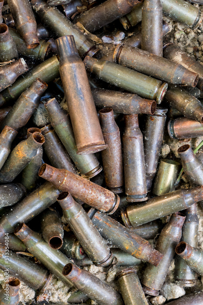 used shells from 5.45 caliber ammunition (from AK-74 5.45×39mm), rust and erosion marks are visible, background