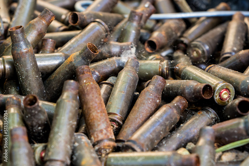 used shells from 5.45 caliber ammunition (from AK-74 5.45×39mm), rust and erosion marks are visible, background photo