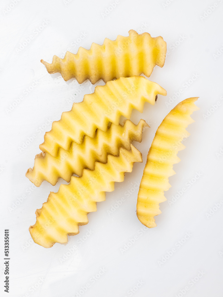 curly knife next to sliced vegetables with a wavy edge curly knife next to sliced vegetables with a wavy edge