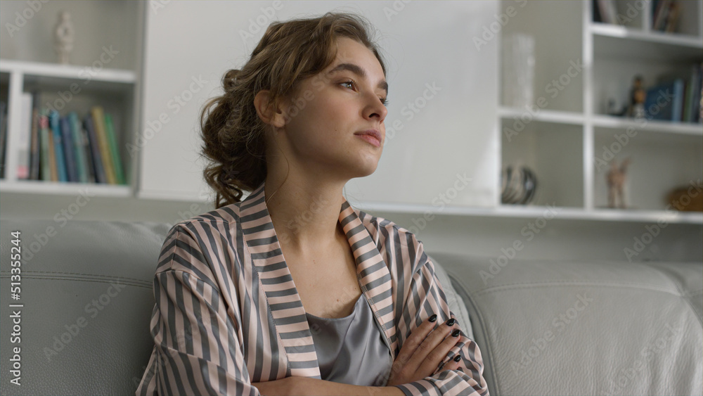 Upset girl thinking problems in pajamas closeup. Beautiful lady posing on sofa Upset girl thinking problems in pajamas closeup. Beautiful lady posing on sofa
