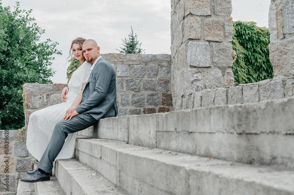 The brides are sitting on the concrete stairs