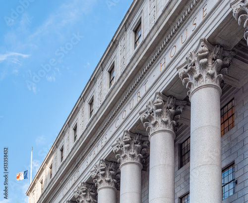 The main entrance of the Thurgood Marshall US Courthouse in NYC is listed on the National Register of Historic Places. The Corinthian columns and the frieze are carved with a detailed floral design. photo