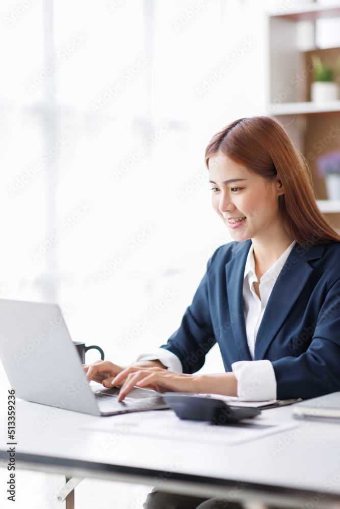 Asian Business woman using calculator and laptop for doing math finance on an office desk, tax, report, accounting, statistics, and analytical research concept Asian Business woman using calculator and laptop for doing math finance on an office desk, tax, report, accounting, statistics, and analytical research concept