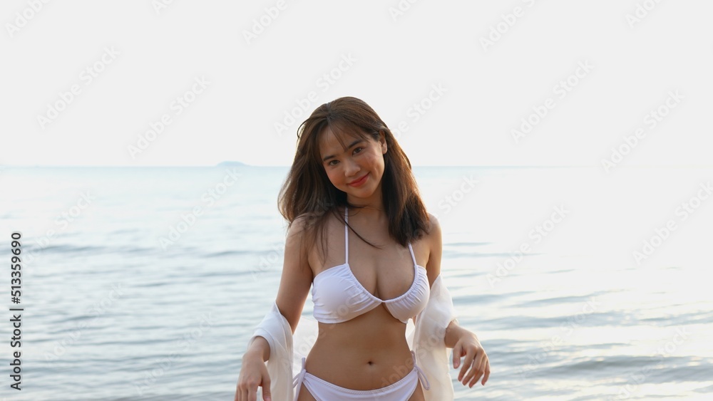 Obraz premium Smiling Young asian woman bikini sexy portrait at seaside beach tropical resting and relaxation travel lifestyle, Happy female freedom on summer vacation time on weekend.